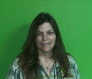 picture of woman smiling in front of green servpro wall